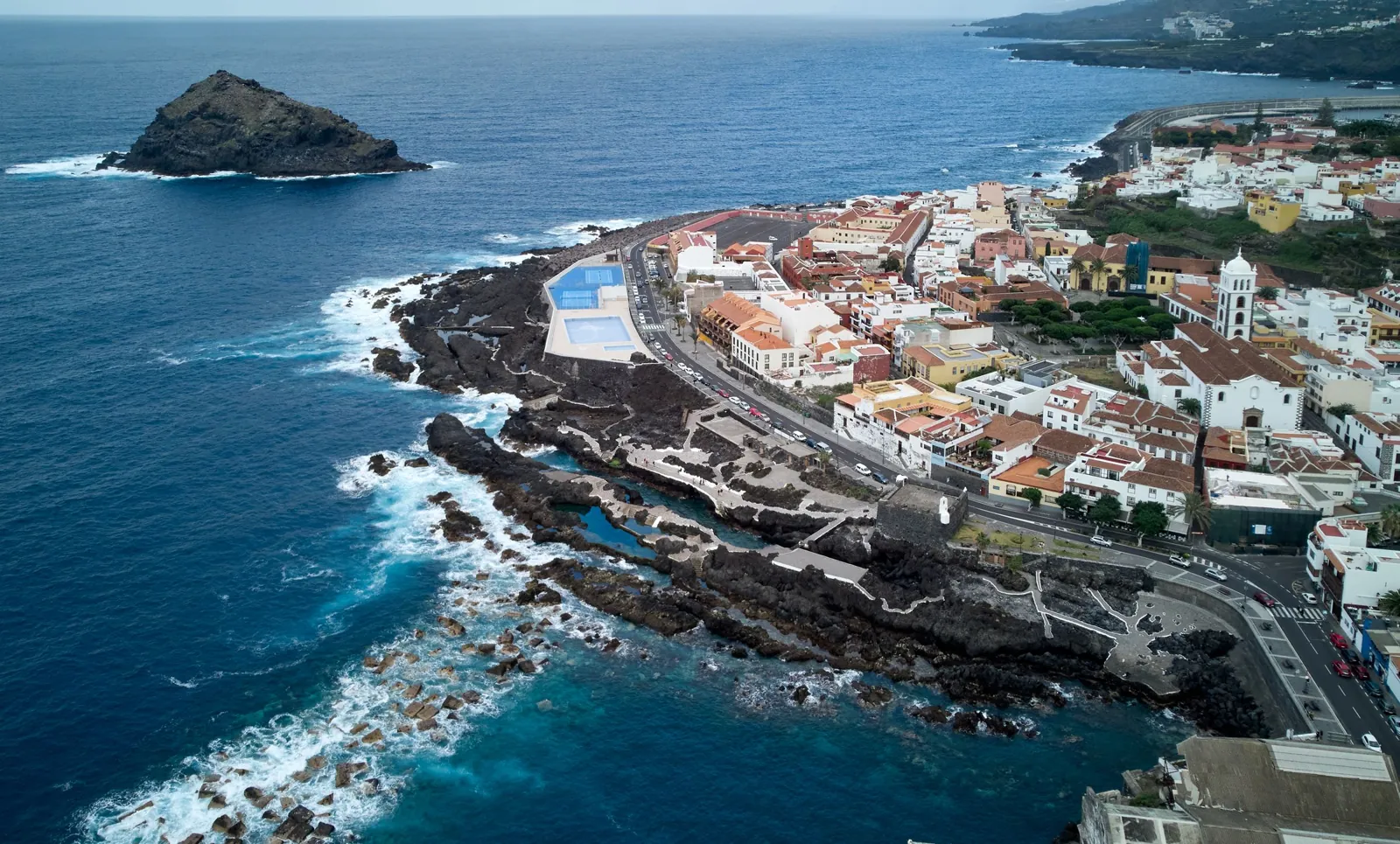 Luftbild von Garachico mit den Naturpools im Lavagestein und dem Felsen Roque de Garachico vor der Küste