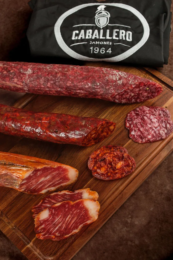 Salchichón, Chorizo und Caña de Lomo von Jamones Caballero auf einem Holzbrett
