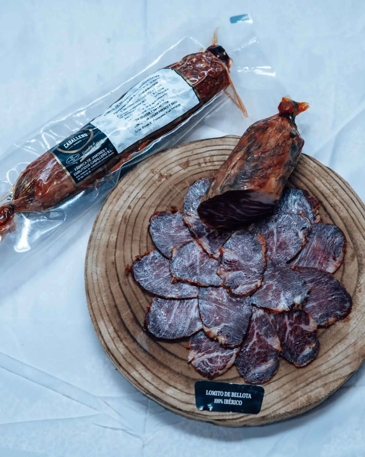 Lomito de Bellota 100 % Ibérico Extra, im Ganzen und in Scheiben auf einem Holzbrett