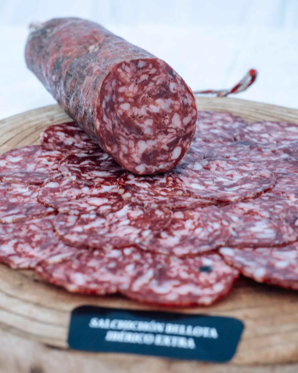 Salchichón de Bellota Ibérico Extra in Scheiben auf einem Holzbrett