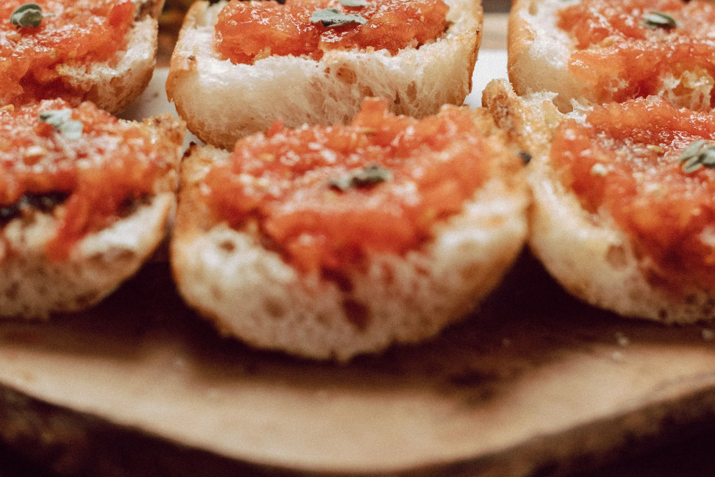 Pa amb tomàquet: geröstetes Brot mit Tomate auf einem Holzbrett