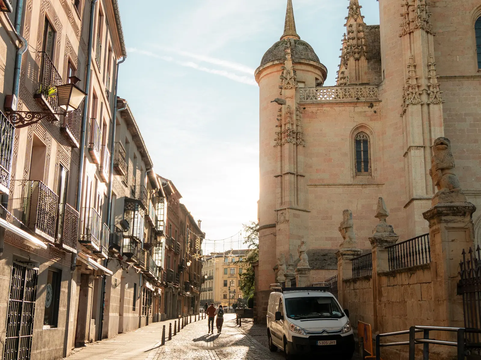 Gepflasterte Gasse in der Altstadt von Segovia, rechts die Kathedrale im Sonnenlicht